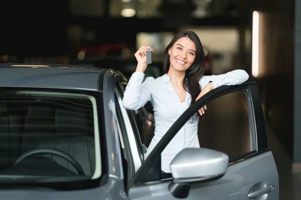 happy woman holding keys to her new car at the royalty free image 1585357275