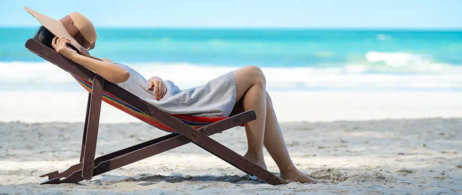 Lady sat on a lounger on a beach